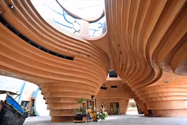 Le Musée de la poterie de Bat Tràng ne passe pas inaperçu dans le quartier avec son architecture fantaisiste, sa façade de couleur marron qui rappelle l’argile, et ses lignes courbes qui donnent l’impression de voir des vases encastrés les uns contre les autres. Photo: VNP