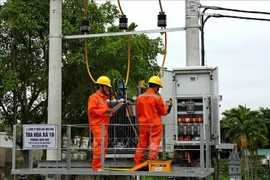 Des employés de la compagnie d’électricité de Hanoi (EVNHANOI) inspectent des équipements électriques. Photo : VNA