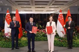 Le secrétaire général du Parti communiste du Vietnam (PCV), Tô Lâm (à gauche), et le Premier ministre singapourien, Lawrence Wong (à droite), assistent à l'échange d'un protocole d'accord sur la transformation numérique entre le ministère vietnamien de la Sécurité publique et le ministère singapourien du Développement numérique et de l'Information, le 12 mars. Photo : VNA
