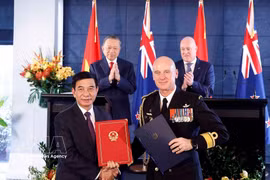 Le secrétaire général et président Tô Lâm (à gauche, deuxième plan) et le Premier ministre néo-zélandais Christopher Luxon supervisent l’échange de documents de coopération entre le Vietnam et la Nouvelle-Zélande. Photo : VNA