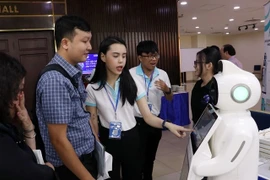 Des délégués découvrent les nouvelles technologies numériques sur le stand d'exposition de la conférence « Promotion des investissements dans les parcs technologiques numériques », à Hô Chi Minh-Ville, le 5 décembre. Photo : VNA