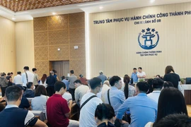 Les gens viennent effectuer des procédures administratives à la succursale n°08 - Point de services administratifs publics de la commune de Dông Anh, n° 66-68 rue Cao Lô, commune de Dông Anh, ville de Hanoi. Photo : VNA