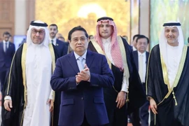 Le Premier ministre Pham Minh Chinh avec les ambassadeurs et le personnel des ambassades d’Arabie saoudite, des Émirats arabes unis et du Qatar à Hanoi, le 24 décembre. Photo: VNA