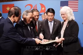 Le président Luong Cuong et les vétérans et les familles des vétérans vietnamiens et américains voient des souvenirs et des documents. Photo: VNA