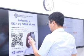 Scanner des codes QR pour accomplir des démarches administratives au siège du Comité populaire du quartier de Cua Nam à Hanoi. Photo : VNA