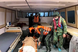 Les secours transportent en toute sécurité Mme Kosuge Kimiko (née en 1949, de nationalité japonaise), victime d'un AVC, à l’hôpital pour des soins d’urgence. Photo : VNA