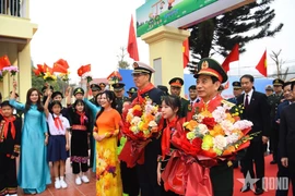 Des élèves offrent des fleurs aux deux ministres de la Défense, Phan Van Giang et Dong Jun Photo : qdnd.vn