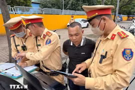 La police de la circulation fournit des images prouvant la violation du règlement par le conducteur d'autobus qui s’est arrêté pour prendre et déposer des passagers sans respecter les règles ou les zones dédiées. Photo : VNA