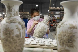 Décoration d'une vase dans le village de céramique de Bat Tràng, en banlieue de Hanoi. Photo : VNA