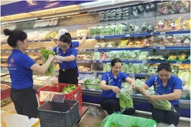 Le personnel de Co.opmart s'affairent à réapprovisionner les marchandises. Photo: Saigon Co.op