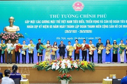 Le Premier ministre Pham Minh Chinh offre des fleurs de félicitations aux jeunes Vietnamiens exemplaires. Photo : VNA