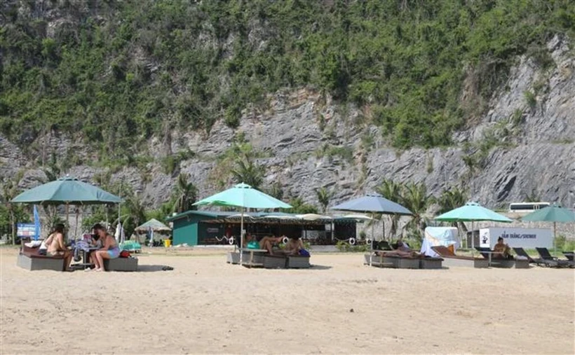 Des touristes étrangers à la plage de Tùng Thu, district de Cat Ba. Photo: VNA