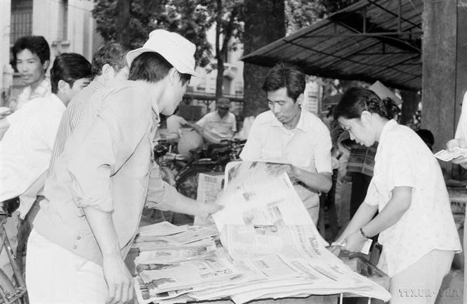 Des habitants de la capitale achètent le « Journal de l'après-midi » de VNA pour suivre les nouvelles de la clôture du 7e Congrès national du Parti (17 juillet 1991). Photo : VNA