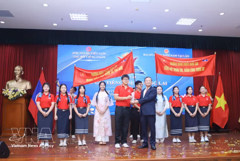 L'ambassadeur Nguyen Minh Tam remet le premier prix à l'équipe de l'École pour surdoués de l'Université nationale du Laos. Photo : VNA
