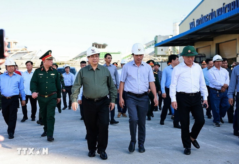 Le Premier ministre Pham Minh Chinh (chemise grise) visite des sites de production endommagés par le typhon Kalmaegi dans la zone économique de Nhon Hoi. Photo : VNA