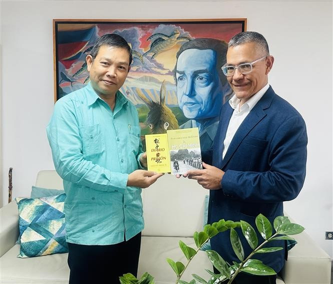 L'ambassadeur vietnamien Vu Trung My (gauche) offre au ministre de la Culture Ernesto Villegas plusieurs œuvres représentatives du Président Hô Chi Minh. Photo: VNA