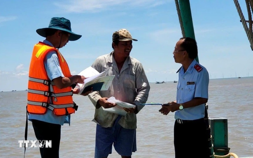 Des agents compétents contrôle un bateau de pêche. Photo : VNA