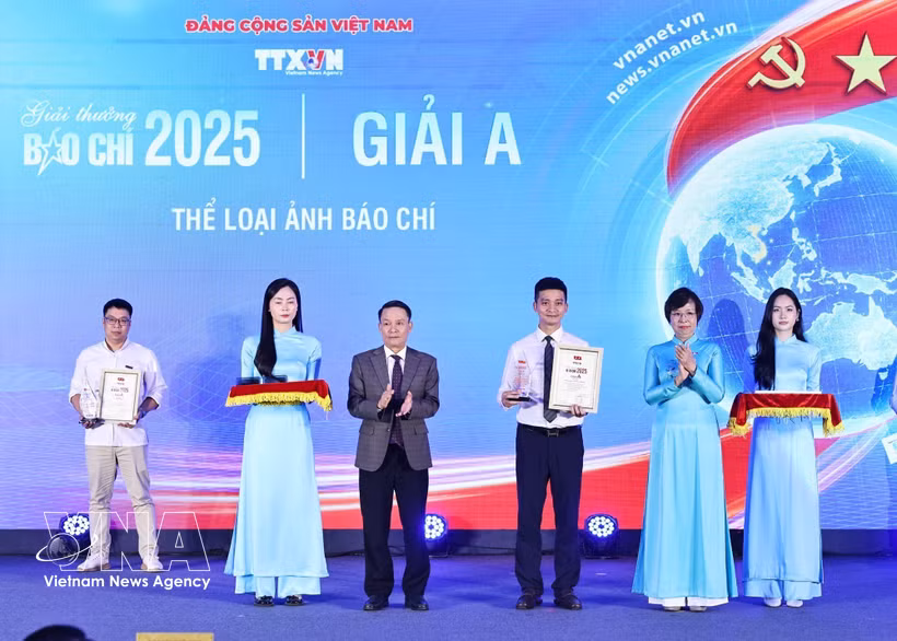 La directrice générale de la VNA, Vu Viet Trang (2e, droite), et le vice-président permanent de l'Association des journalistes du Vietnam, Nguyen Duc Loi (3e, gauche), remettent le prix A à un ouvrage des correspondants de la VNA. Photo : VNA