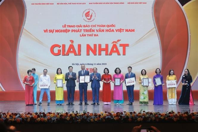 Le vice-Premier ministre Mai Van Chinh (4e, gauche) et le ministre de la Culture, des Sports et du Tourisme, Nguyen Van Hung (6e, gauche), remettent le premier prix aux auteurs et aux groupes d'auteurs lauréats. Photo : VNA