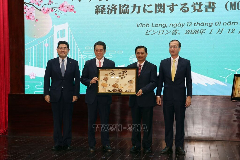 Le secrétaire du comité provincial du Parti de Vinh Long,Tran Van Lau (2e, à droite), remet un cadeau à Tokihiro Nakamura (2e, à gauche), gouverneur de la préfecture japonaise d'Ehime. Photo : Pham Minh Tuan - VNA.