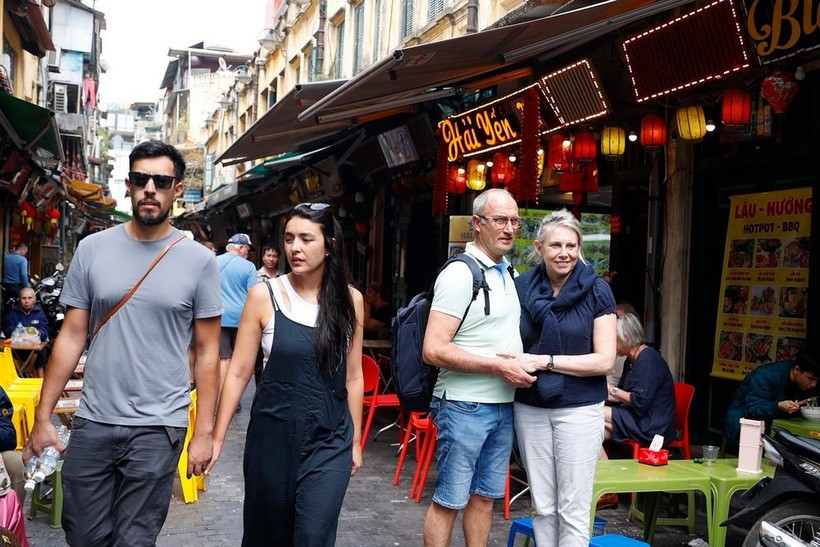 Des touristes étrangers visitent des rues de Hanoï. Photo: VNA