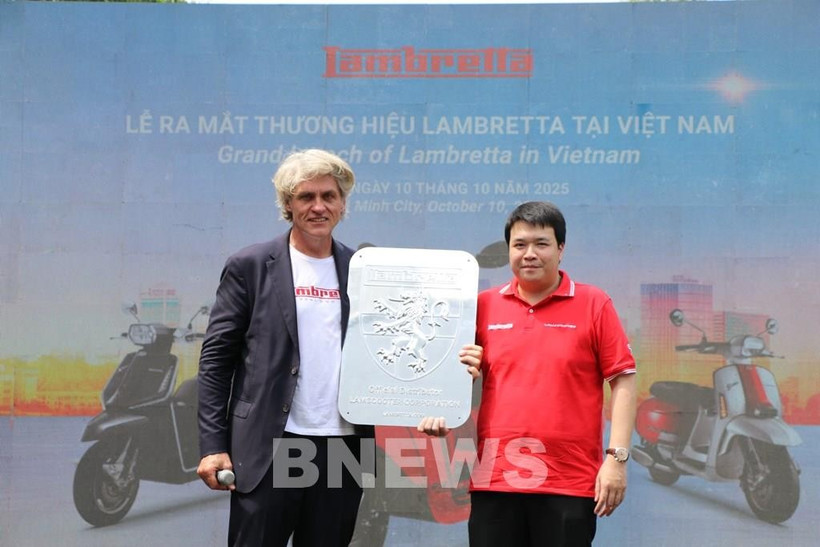Un représentant de Lambretta remet le logo de l'entreprise à son distributeur officiel, la société Lamscooter Vietnam. Photo : VNA