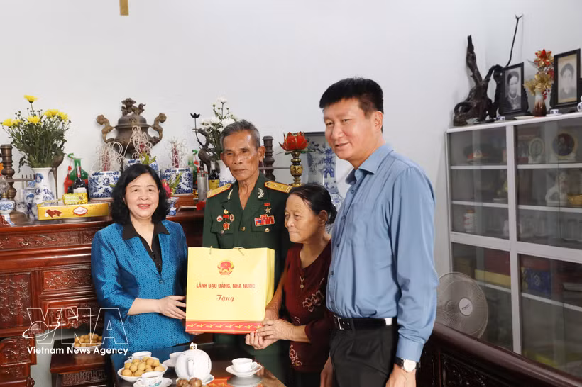 Mme Bui Thi Minh Hoai (premier, gauche), secrétaire du Comité central du Parti et présidente du Comité central du Front de la Patrie du Vietnam, offre un cadeau à la Mère vietnamienne héroïque Tran Thi Sach, née en 1920. Photo: VNA