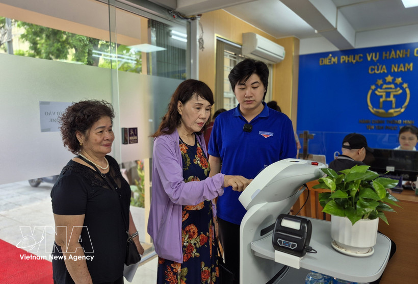 Des citoyens découvrent des robots dotés d'intelligence artificielle. Photo : VNA