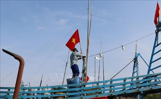 Les pêcheurs hissent le drapeau national pour affirmer la souveraineté des mers et des îles du pays. Photo: VNA