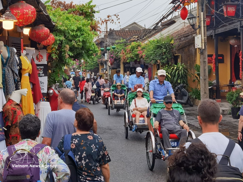 Touristes vietnamiens et étrangers à Hoi An. Photo : VNA