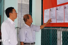 Des électeurs consultent les brèves biographies des candidats au Conseil populaire de la commune de Tan Hong, province de Dong Thap, mandat 2026-2031. Photo : VNA
