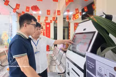 Des agents du Centre de services administratifs publics de la commune de Chi Lang, dans la province de Lang Son, guident les habitants dans l'utilisation du KIOSK de services publics assisté par l'intelligence artificielle (IA). Photo : VNA