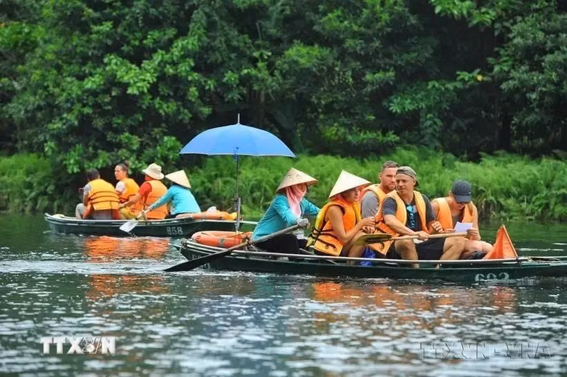 Des touristes nationaux et étrangers visitent la zone touristique de Trang An (Ninh Binh). Photo: VNA
