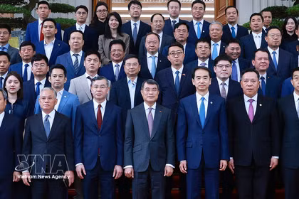 Le Premier ministre Le Minh Hung (au centre de la première ligne) et des représentants d' entreprises chinoises implantées au Vietnam. Photo: VNA