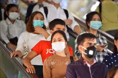 Les gens portent des masques pour prévenir l'infection au COVID-19 à Bangkok, en Thaïlande. Photo: Xinhua/VNA
