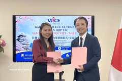 Les représentants du VJCE et de l'École de langue japonaise Aoyama procèdent à l'échange de l'accord de coopération signé. Photo: VNA