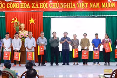 Le Premier ministre Pham Minh Chinh remet des cadeaux à des familles bénéficiaires de politiques sociales. Photo: VNA