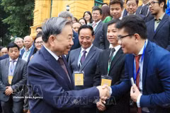 Le secrétaire général du Parti et président Tô Lâm (gauche) et des représentants des Vietnamiens à l'étrangers. Photo: VNA