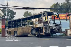 La carcasse calcinée de l'autocar est remorquée pour les besoins de l'enquête. Photo: VNA