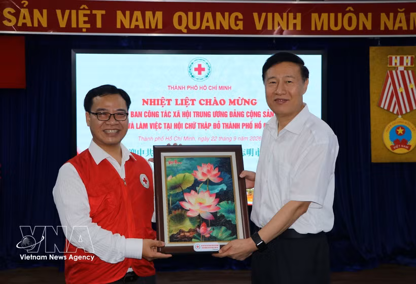Nguyen Minh Nhut, président de la Croix-Rouge de Hô Chi Minh-Ville, remet un souvenir à Zhao Shi Tang, vice-directeur du Département du travail social du Comité central du Parti communiste chinois. Photo : VNA