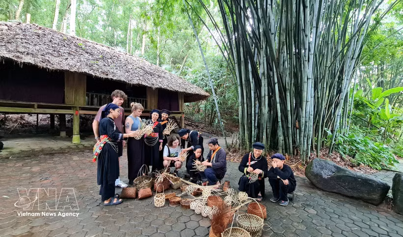 Des touristes étrangers découvrent le village culturel de Thai Hai, dans la commune de Tan Cuong, province de Thai Nguyen. Photo : VNA