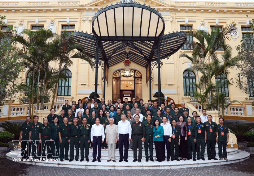 Le secrétaire général du Parti communiste du Vietnam et président de la République, Tô Lâm, et des délégués de l’Association des anciens Jeunes volontaires du Vietnam. Photo : VNA