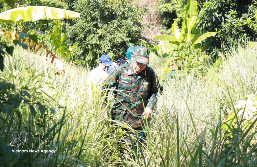 Les forces participant aux opérations de reconnaissance et de recherche des restes des martyrs progressent à pied à travers les forêts. Photo : VNA