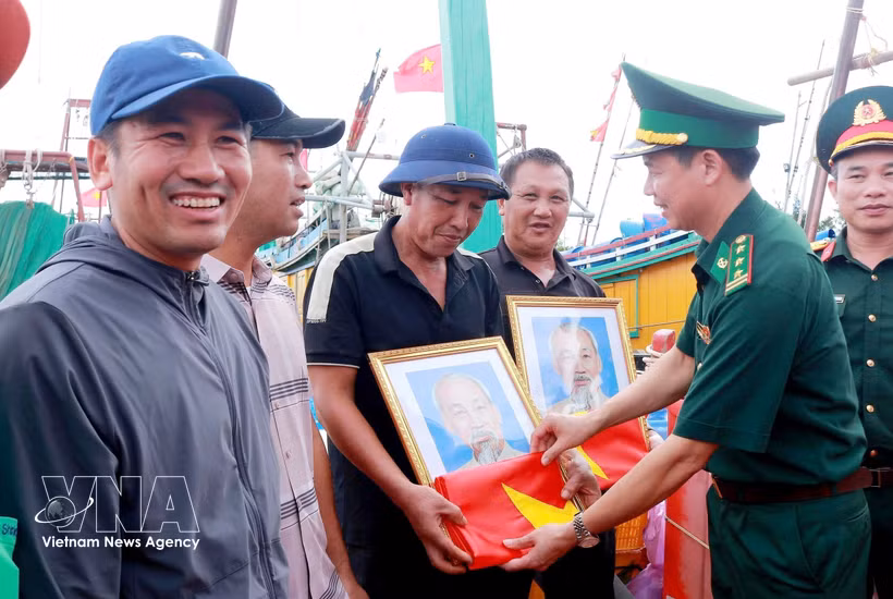 La Fédération et le Commandement provincial des gardes-frontières ont remis aux pêcheurs 400 drapeaux nationaux et 120 portraits du Président Hô Chi Minh. Photo: VNA