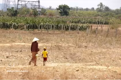 Une grand-mère et son petit-enfant, membres de l'ethnie Rai de la commune de Hàm Cân, ancienne province de Binh Thuân, vont acheter de l'eau sous la chaleur de midi, en 2024. Photo : VNA