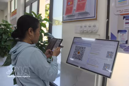 À Dà Nang, une résidente utilise un code QR pour obtenir son numéro de passage au Centre de services administratifs du quartier de Hoa Xuân. Photo: VNA