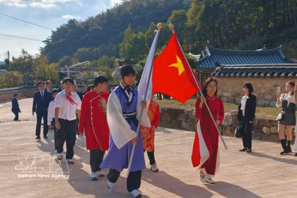 Deux drapeaux ouvraient la marche du cortège «Le Dragon qui revient» alors qu’il pénétrait dans le Trung Hiêu Duong. Photo : VNA