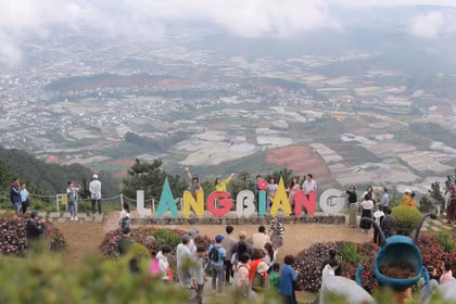 Des visiteurs découvrent la culture des gongs dans un village au pied du mont Lang Biang. Photo: vietnamtourism.gov.vn