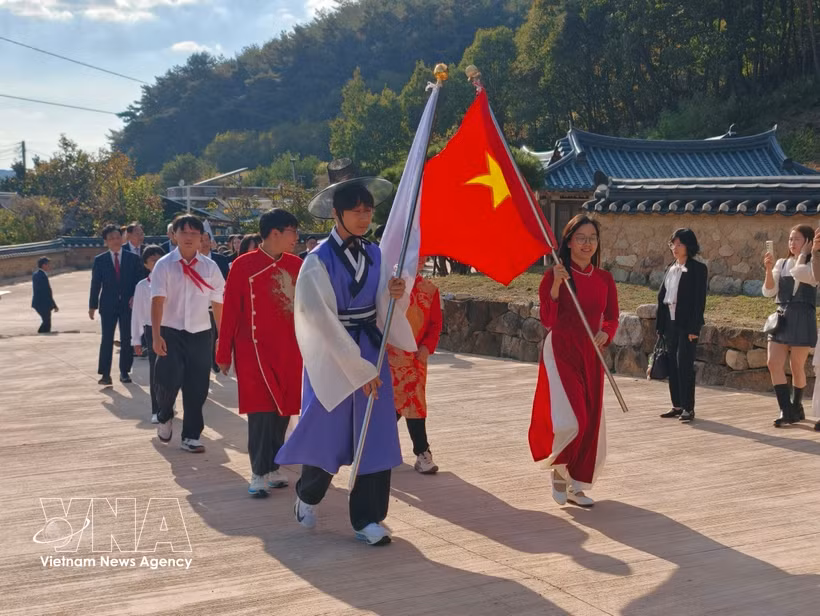 Deux drapeaux ouvraient la marche du cortège «Le Dragon qui revient» alors qu’il pénétrait dans le Trung Hiêu Duong. Photo : VNA