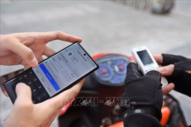 La limite mensuelle de 100 millions de dôngs s'applique aux transferts d'argent et aux paiements effectués via un seul compte Mobile Money. Photo : VNA